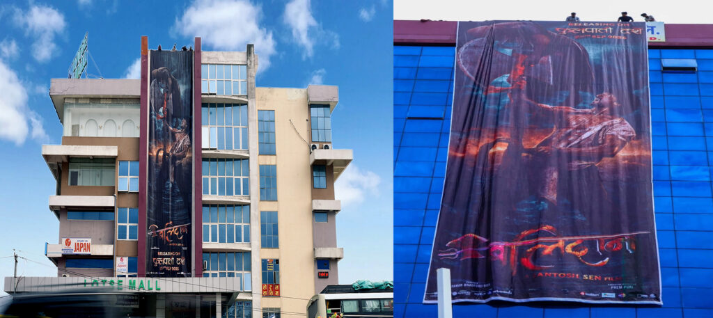 Sixthury‑pixel view of Samir Bhatt in blood‑soaked avatar on a 60‑ft tall poster at Many Cinema Halls in Kathmandu & Friends Cinemas Dharan.